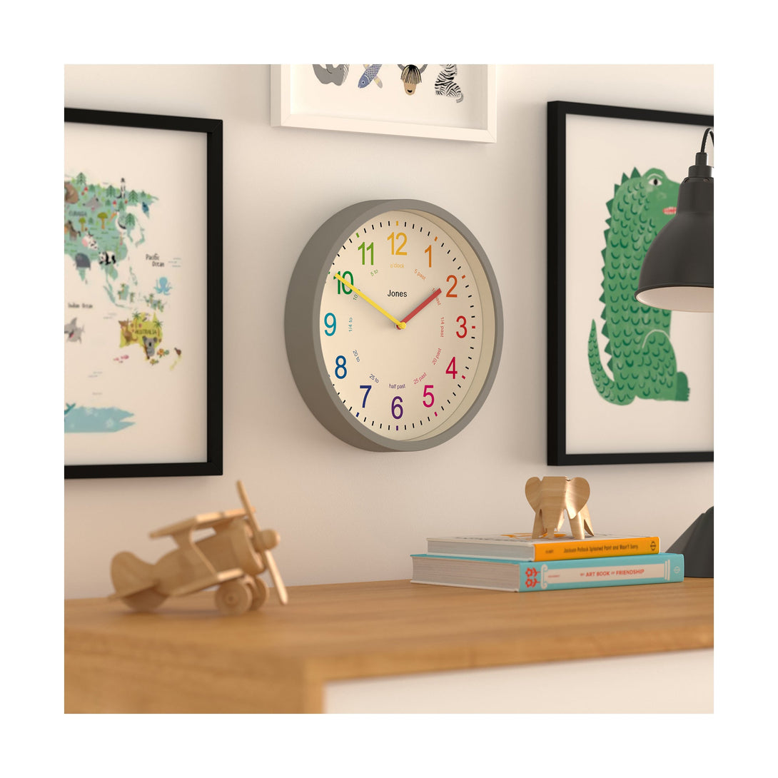 Kids wall clock by Jones Clocks in grey with a multi-coloured, easy-to-read dial - JDRAG73PGY