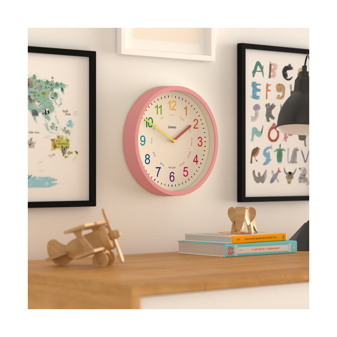 Kids wall clock by Jones Clocks in pink with a multi-coloured, easy-to-read dial - JDRAG73MPK