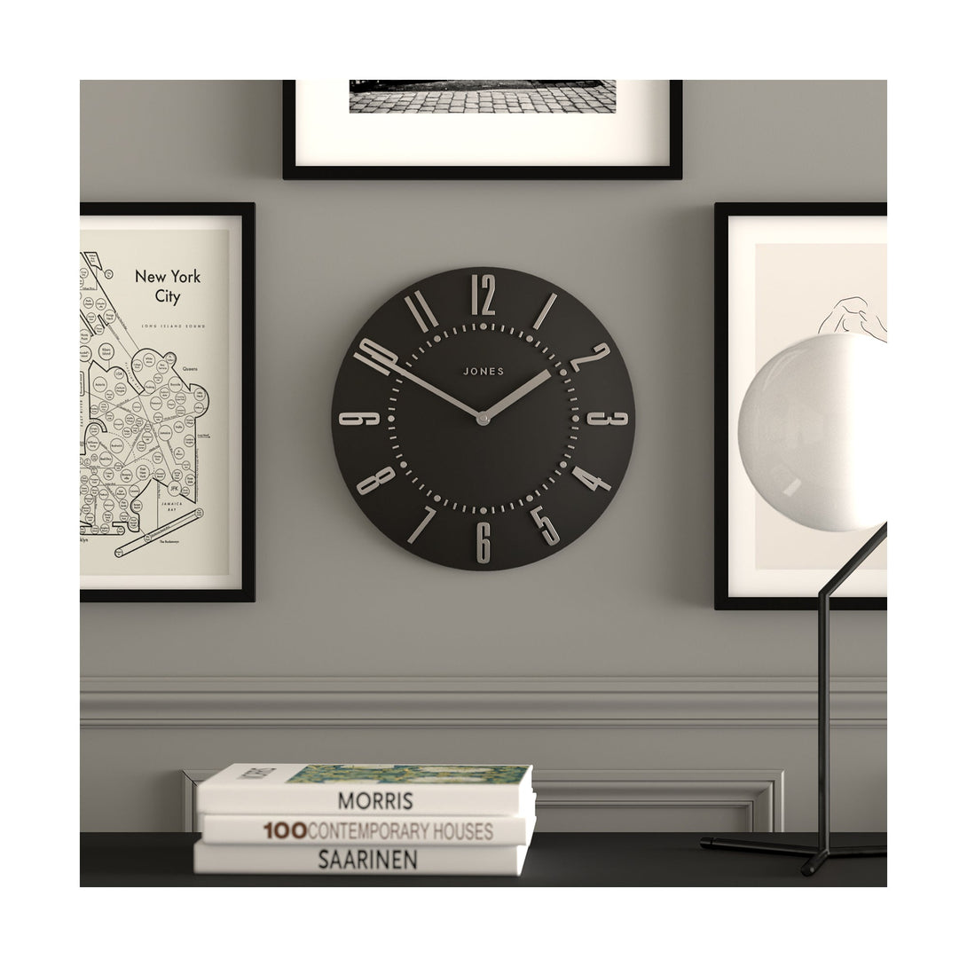 Juke Convex wall clock by Jones Clocks in dark grey with a retro style silver dial, hanging on a living room wall - JJUKEBGYS30
