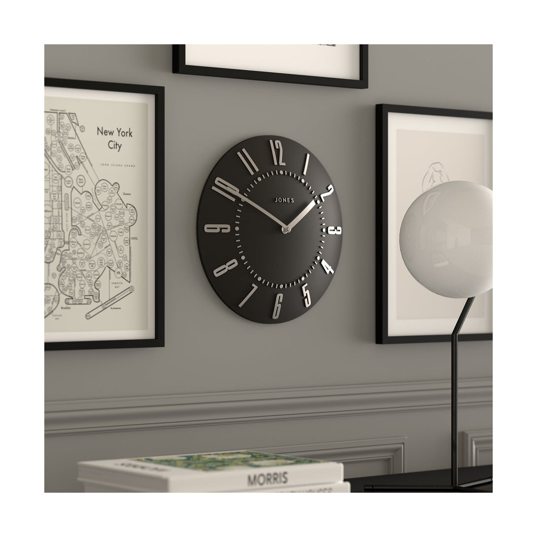 Juke Convex wall clock by Jones Clocks in dark grey with a retro style silver dial, hanging on a living room wall - JJUKEBGYS30