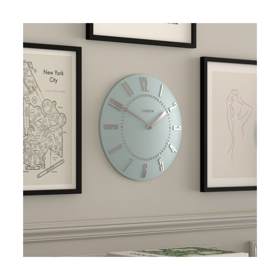 Juke Convex wall clock by Jones Clocks in pale blue with a retro style silver dial, hanging on a living room wall- JJUKECBLS30