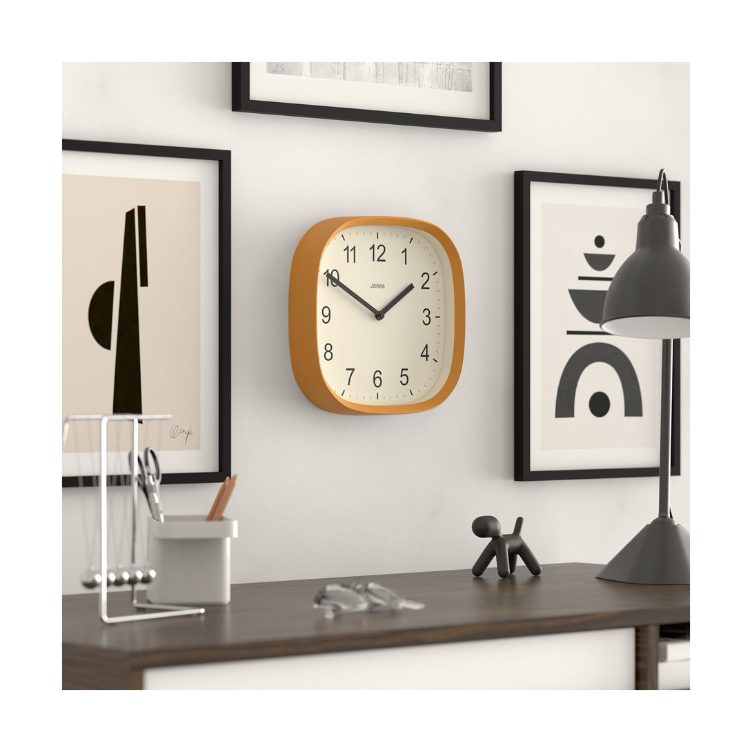 Office skew - Sprite wall clock By Jones Clocks with a rounded square case in a mustard yellow. Clear contemporary Arabic dial - JSPARV104MY