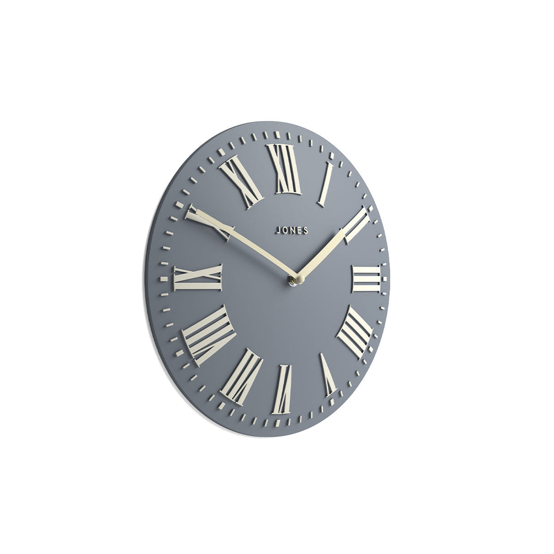 Skew - Strand convex wall clock by Jones Clocks. Prominent white Roman duals on a medium blue grey background, offering a modern look - JSTRFNLW30