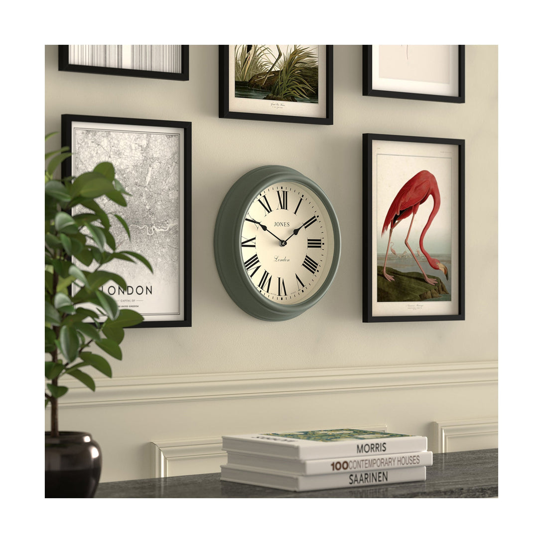 Gallery wall skew - Venetian wall clock by Jones Clocks. A classic Roman numeral dial with traditional spade hands, inside a decorative moss green case - JVEN319ASG