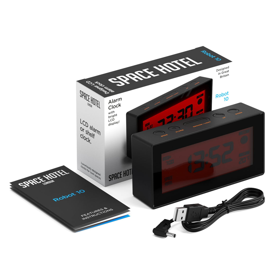 Skewed view of the Space Hotel Robot 10 LCD alarm clock in black with a red backlight, with box, instructions and USB Cable