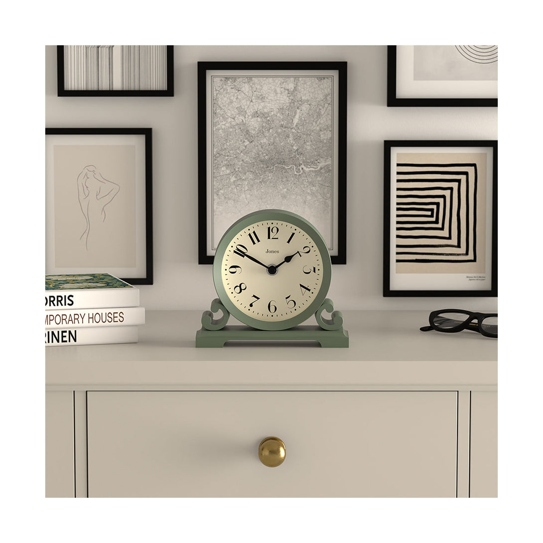 Style shot - Saloon decorative mantel clock by Jones Clocks in moss green with a modern stylistic Arabic dial and metal spade hands - JSAL192ASG