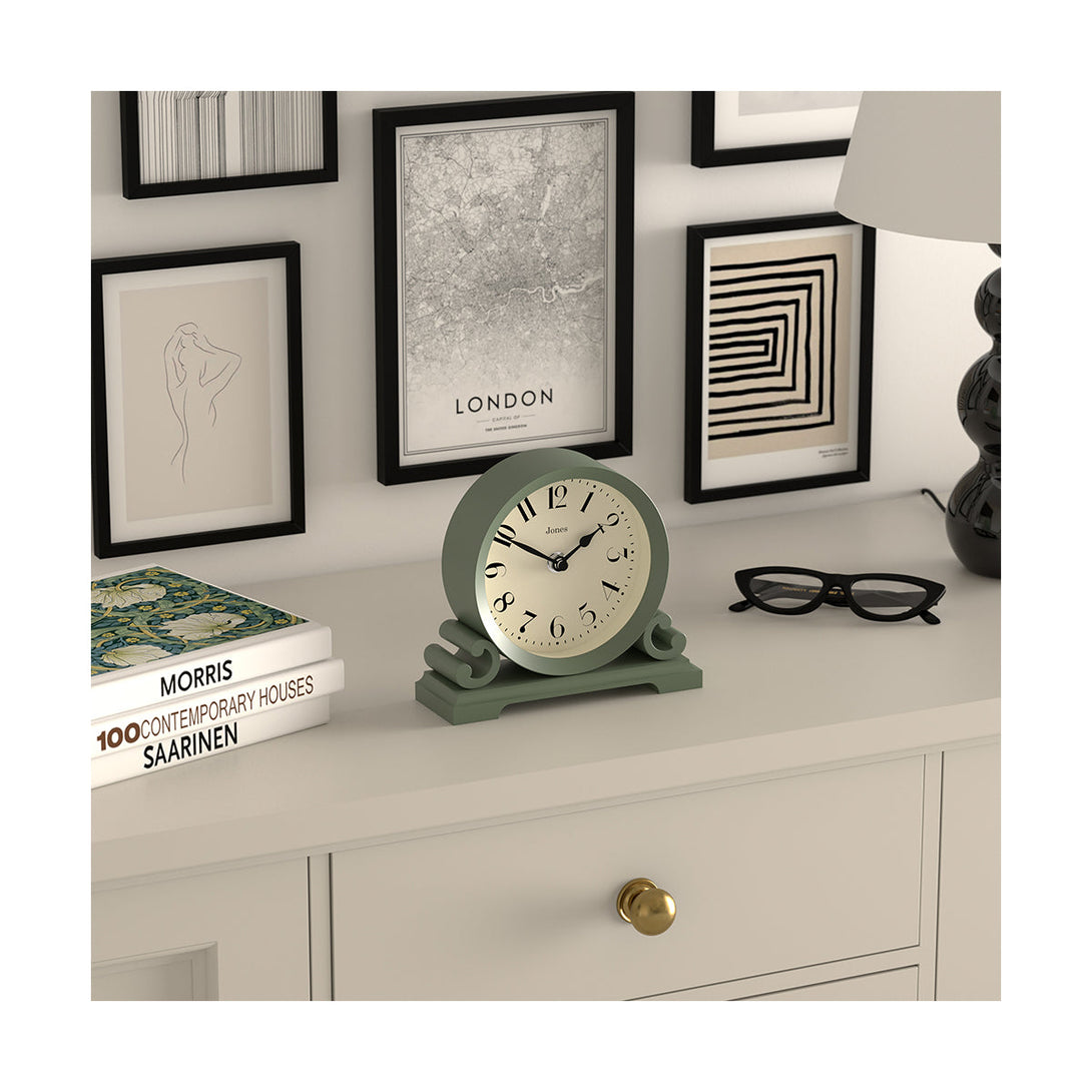 Skew style shot - Saloon decorative mantel clock by Jones Clocks in moss green with a modern stylistic Arabic dial and metal spade hands - JSAL192ASG