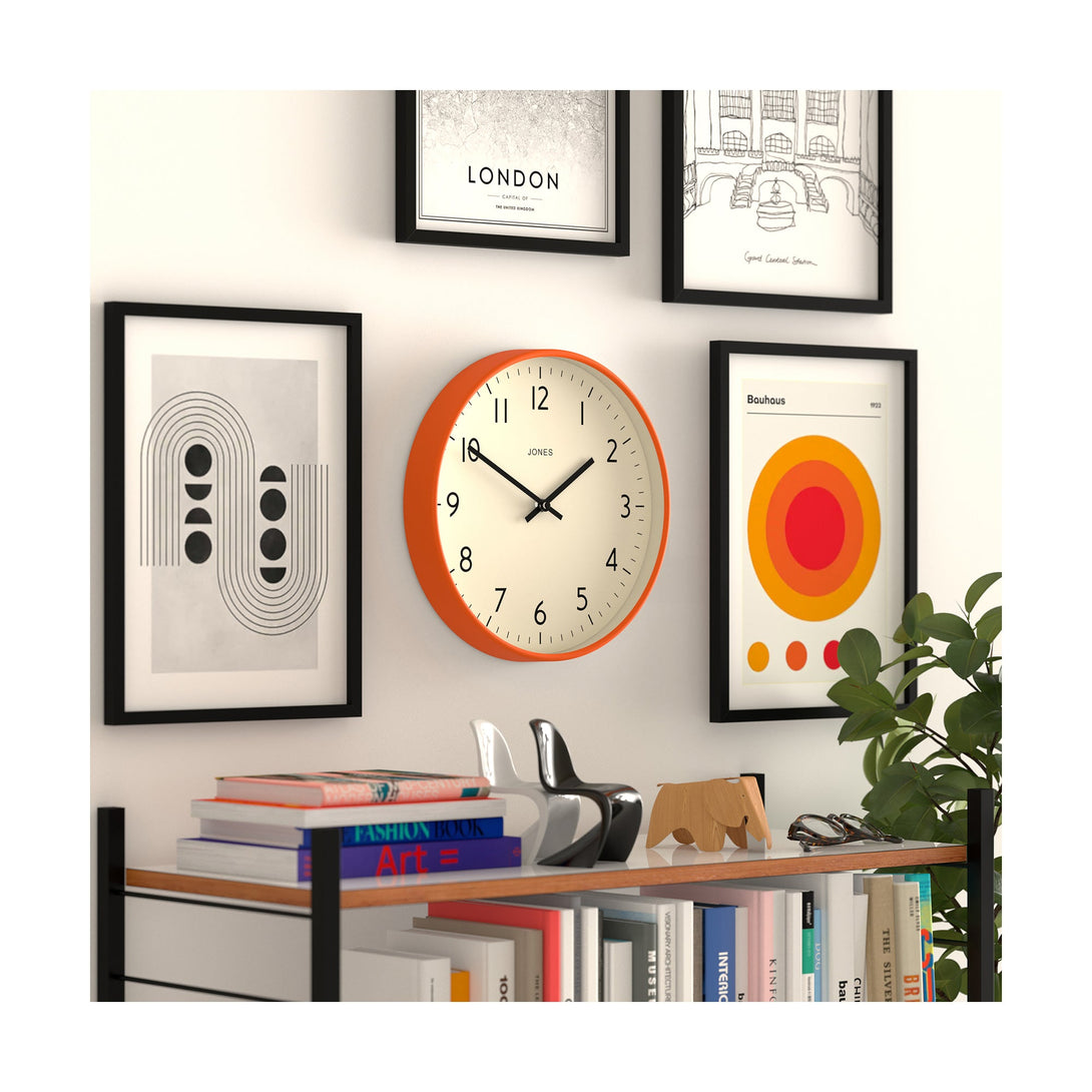 Skew style shot - Studio wall clock by Jones Clocks in orange with an easy-to-read and minimalistic dial - JPEN52FO